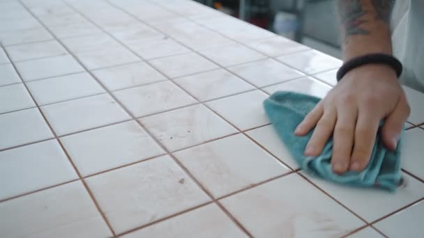 Tattooed man applies ceramic tiles on kitchen table set — Stock Video