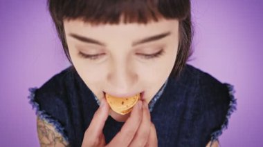 Çekici esmer aydınlık arka izole macarons yiyor