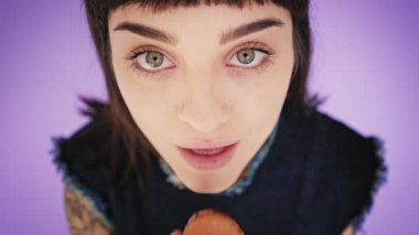 Çekici esmer aydınlık arka izole macarons yiyor