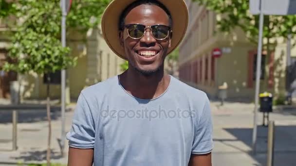 Joven hombre negro hipster camina por la ciudad — Vídeo de stock