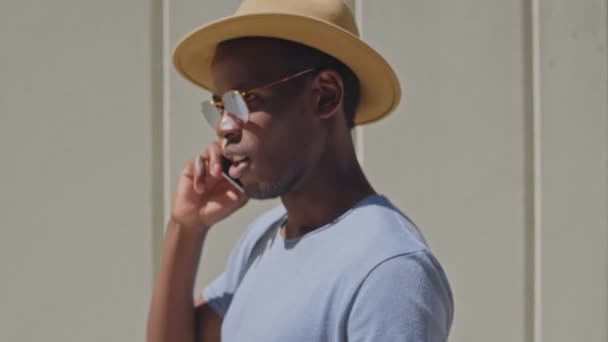 Genç siyah hipster adam şehrin içinden yürür — Stok video