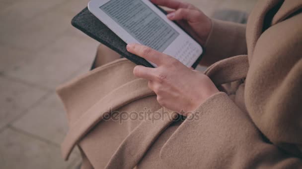 Dziewczyna z czytnika książek elektronicznych na ulicy — Wideo stockowe
