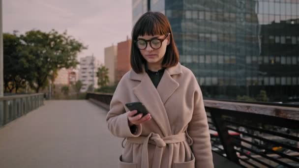 Atraktivní bruneta holka chodí na městských ulicích — Stock video