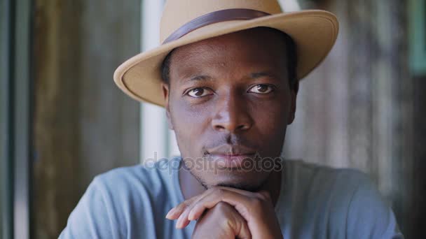 Joven hombre negro se sienta en un café de moda — Vídeos de Stock