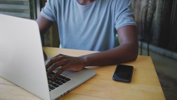 Jonge zwarte man zit in een trendy café — Stockvideo