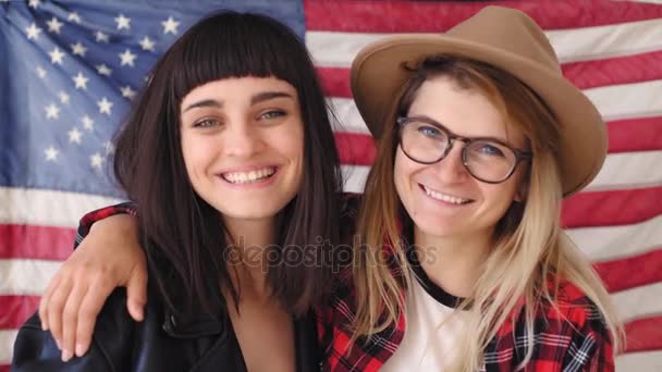 Blonde et brune hipster filles tenir un drapeau — Video