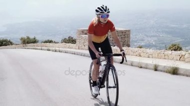 Genç sarışın kadın bisikletçi bisiklet sürmek