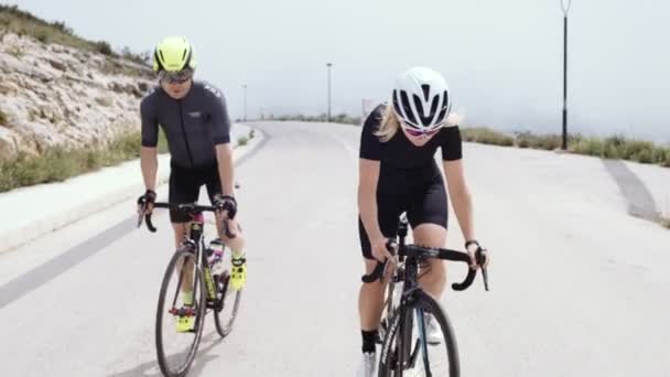 Två professionella road cyklister rida sina cyklar på en kulle — Stockvideo