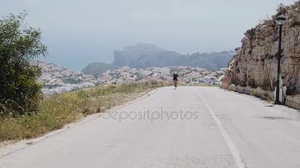 Профессиональный триатлонист поднимается на холм — стоковое видео