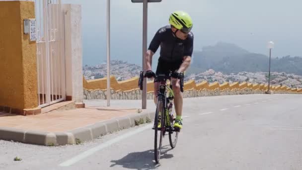 Profesional triatleta masculino sube una colina — Vídeo de stock