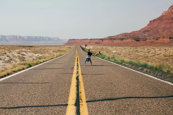 Nuori mies tekee pyörän moottoritiellä — kuvapankkivalokuva