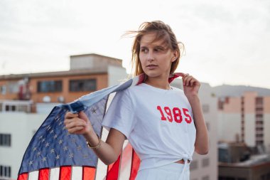 Sarışın kadın model Amerikan bayrağı tutar