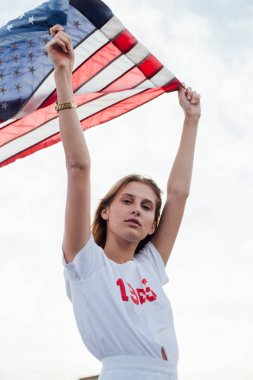 Sarışın kadın model Amerikan bayrağı tutar