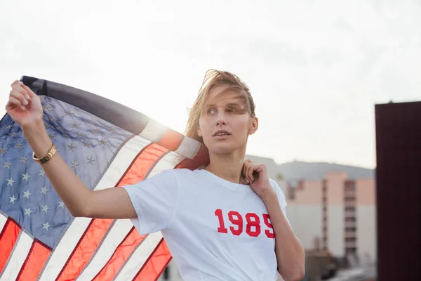 Bionda modello femminile regge bandiera americana — Foto Stock