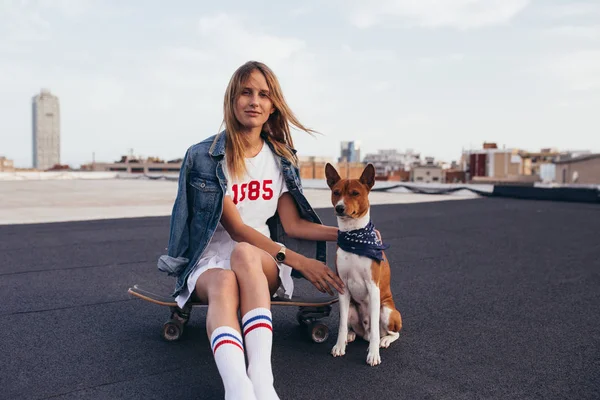 Krásná blondýna v džínové bundě s skateboard — Stock fotografie