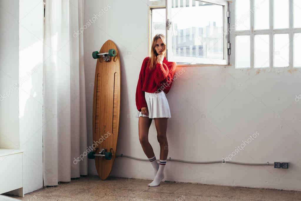 Blonde model in cute outfit with longboard
