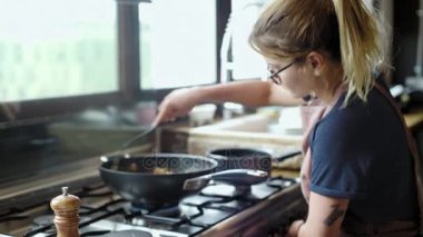 Sarışın kadın bir tabak kızartma tavası içinde hazırlar