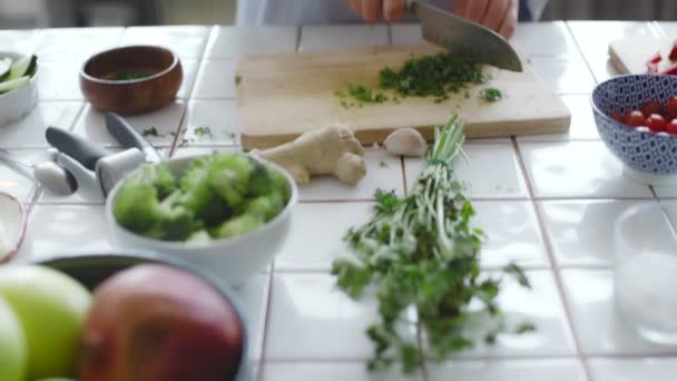 Mãos cortando legumes na tábua de corte de madeira — Vídeo de Stock