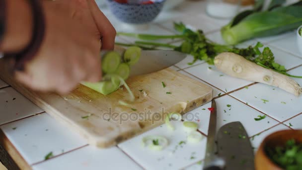 Mãos cortando legumes na tábua de corte de madeira — Vídeo de Stock