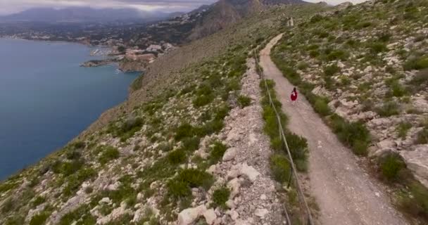 Antenn skott av liten flicka kör på bergsstig — Stockvideo