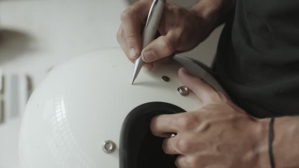Художник рисует ручные надписи на винтажном шлеме — стоковое видео