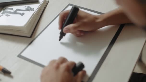 Young and beautiful male writes messages on white paper sheet — Stock Video