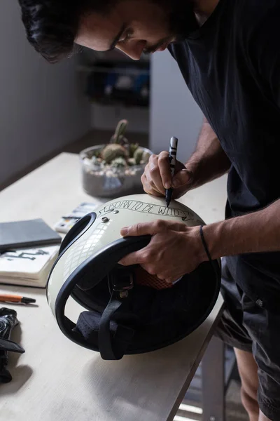 Kaligrafia artysta dostosowuje kask motocykl — Zdjęcie stockowe