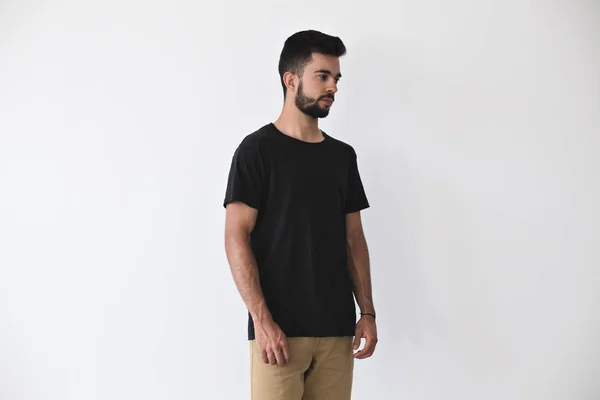 Привлекательный мужчина позирует в черной простой футболке — стоковое фото