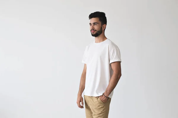Красивый молодой человек позирует в белой футболке — стоковое фото