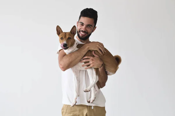 Yakışıklı adam alçaklık köpek tutar — Stok fotoğraf