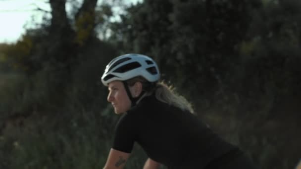 Kadın yol bisikletçi günbatımında — Stok video