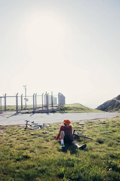 Cyklist som vilar på gräs — Stockfoto