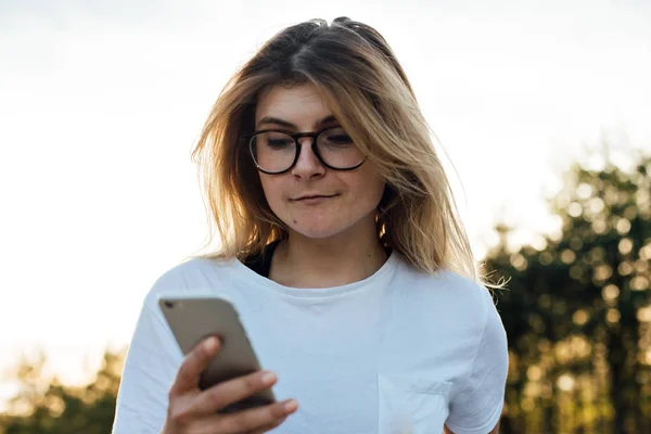 Mädchen mit blonden Haaren nutzt Smartphone — Stockfoto