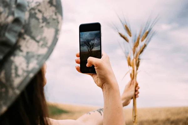 Girl taking photo of freshly picked wheat — Stock Photo, Image