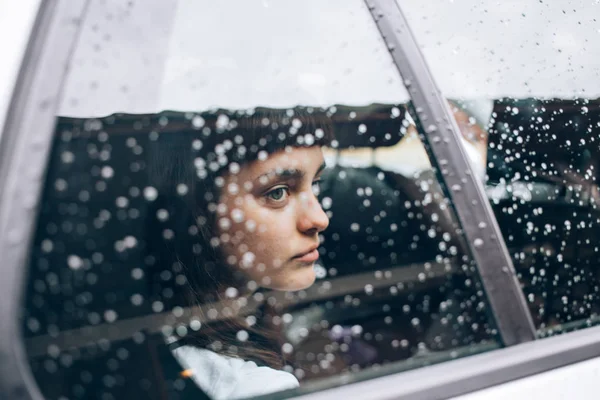 Verdrietig meisje zit in de auto — Stockfoto