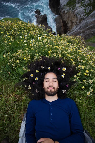 bearded man with flowers in hair