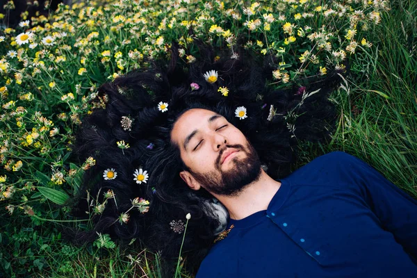 Homem barbudo com flores no cabelo — Fotografia de Stock