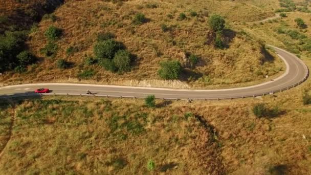 Rotes Auto folgt auf Motorrad auf Straße — Stockvideo