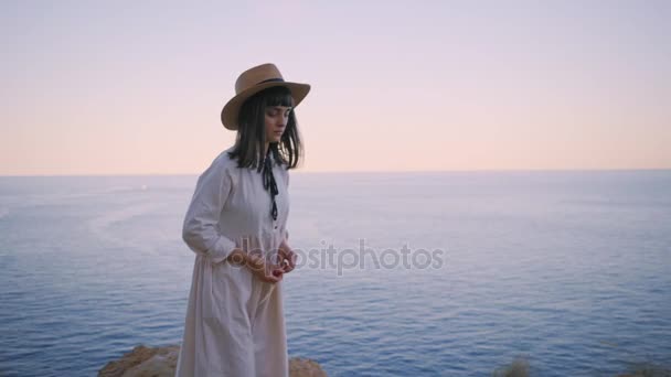 Girl walks on the edge of cliff next to ocean — Stock Video