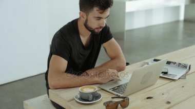 Genç öğrenci çalışmalarının hipster kafe içinde laptop