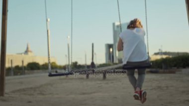 Bahçesi swingset üzerinde sallanan kadın