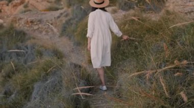 Beyaz elbiseli kadın yolda yürüyor