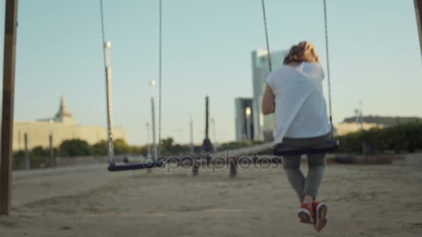 Kobieta, kołysanie na plac zabaw swingset — Wideo stockowe