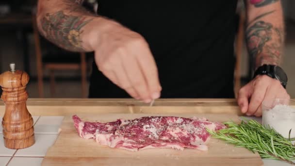 Adam dinlendirir ve baharatlar ile taze biftek mevsim — Stok video