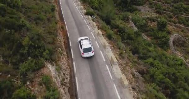 Повітряний дрон після автомобіля через гірську дорогу — стокове відео