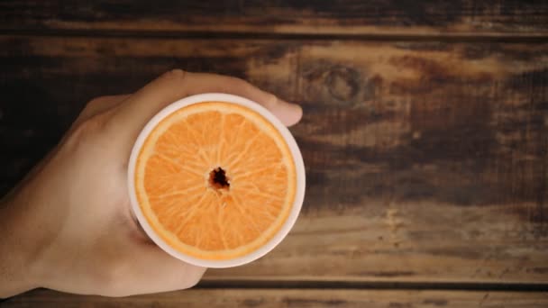 Vista superior de la mano con vidrio y rebanada de naranja en el interior — Vídeo de stock