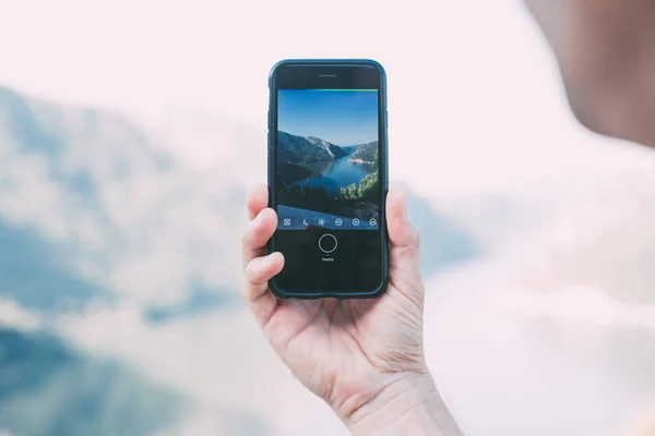 Toeristische maakt foto van sea met smartphone — Stockfoto