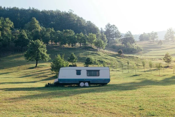 Trailer on side of mountain hill in grass — Stock Photo, Image