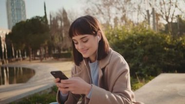 Güzel kadın smartphone parkta kullanır.