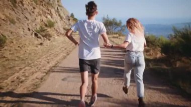 Dağ yolundan günbatımı üzerinde genç hippi çift yürüyüşlere